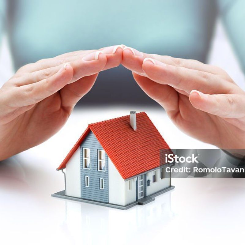 hands covering house - insurance concept - real estate
